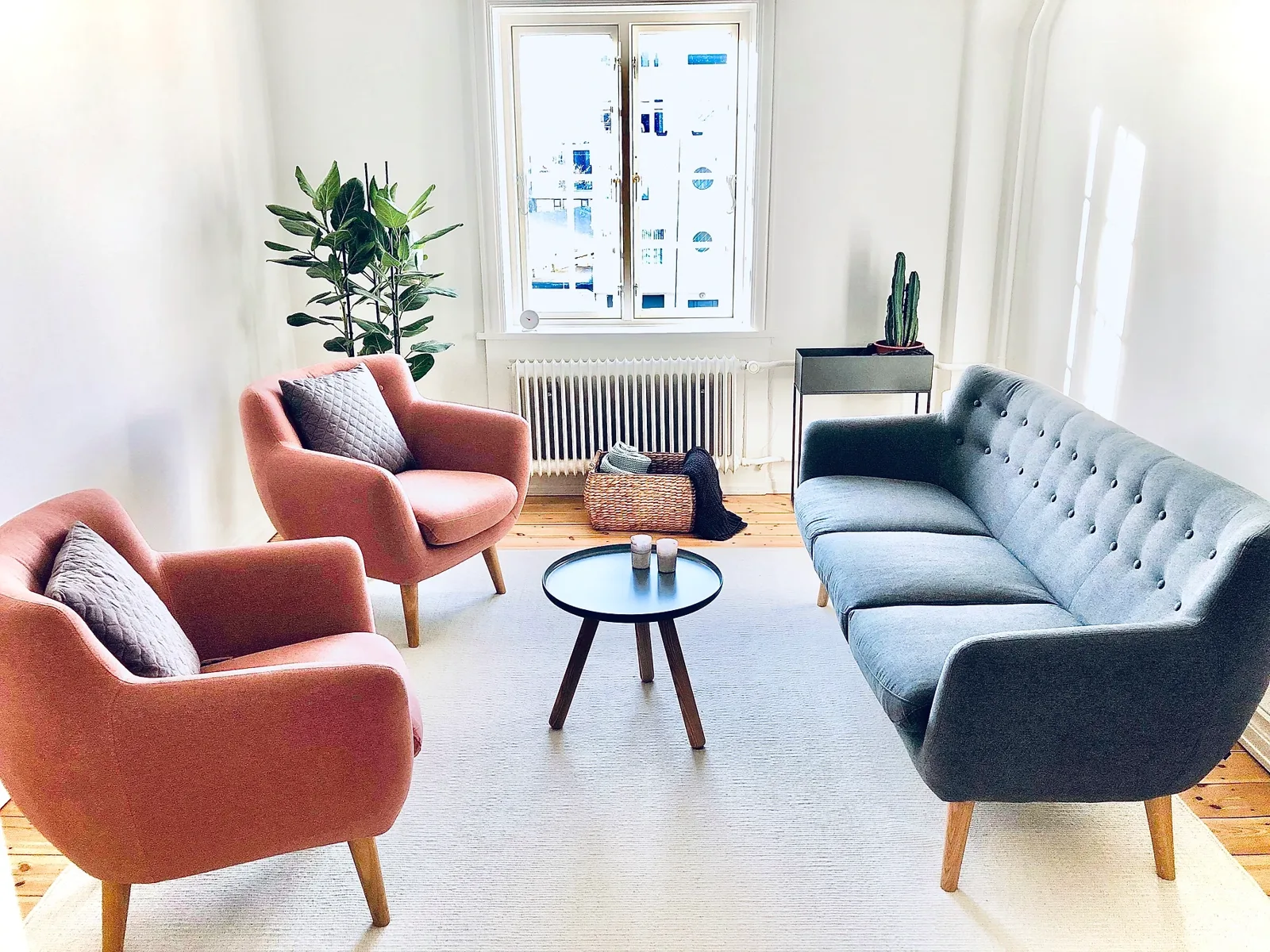 Lyst samtalerum i klinikken på Holbergsgade med lænestole, sofa og planter